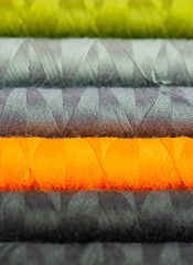 Nähgarnrollen in diversen Farben bei einer Schneiderei vor weißen Hintergrund 