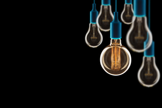 Idea and teamwork concept - Vintage incandescent bulbs on black background