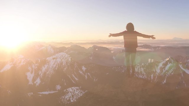 Fantasy Adventure Composite with a Girl on top of a Rock Cliff with Beautiful Canadian Mountain Nature Landscape in Background during Sunset or Sunrise. 2.5D Parallax