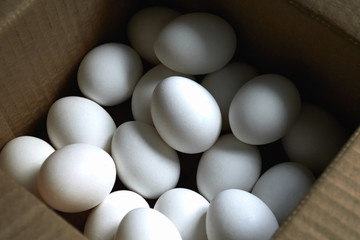 White eggs of oval shape in a brown box in the daytime on the top view. The concept of agricultural production