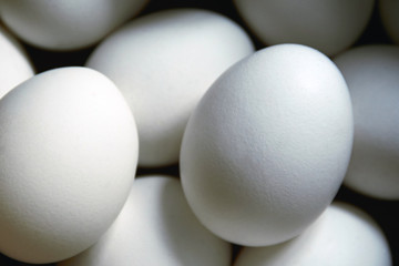 White oval-shaped chicken eggs in a brown box in the daytime close-up. The concept of agricultural production