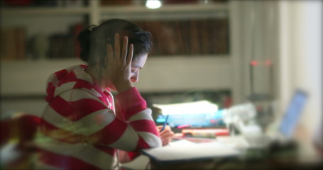 Casual woman studying late at night. Candid person working from home.