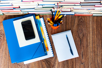 Fototapeta premium Textbook, notebook, mobile phone smartphone, stack of books. Home distance education background, stay home concept.