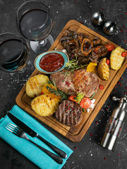 Meat grill set with wine on black wooden background