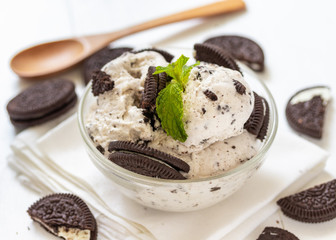 Chocolate cookie and ice cream in a glass bowl with mint leaf on white wooden background, summer sweet and dessert
