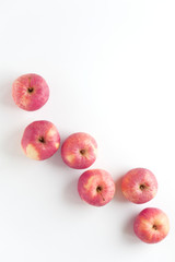 Red apples laid out in a row on a white background. Fruit composition, pattern, vitamin food poster. Vertical top view, flat lay, copy space.