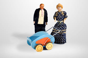 Vintage dolls with stroller, man in dark suit and woman in long dress