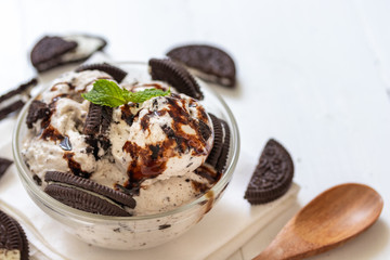 Chocolate cookie and ice cream in a glass bowl with mint leaf on white wooden background, summer sweet and dessert