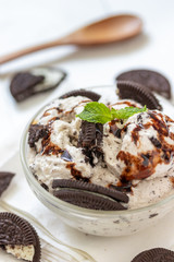 Chocolate cookie and ice cream in a glass bowl with mint leaf on white wooden background, summer sweet and dessert