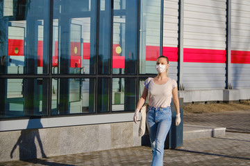 European woman in protective mask and gloves walking outdoors...