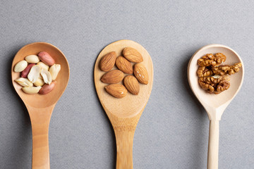 Spoons with walnuts, almonds and peanut. Flat lay