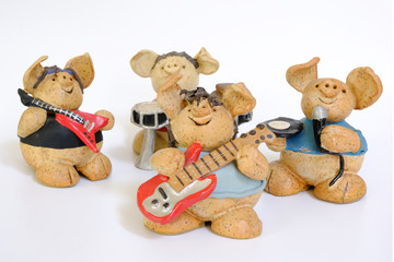 Figure of a ceramic pig playing music bassist, guitarist, singer and drummer