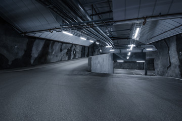 Sci fi looking dark and moody underground parking lot with fluorescent lights on.  Two ways © Nerijus