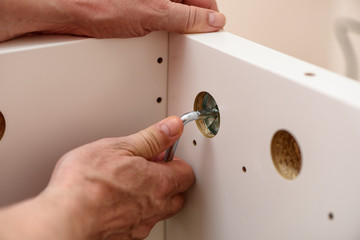 Close up on hands with Allen key assembling furniture