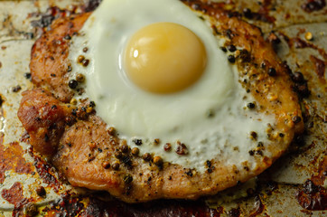 Fried portion of gammon served with egg on the metal plate