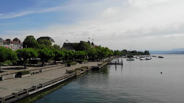Drone Shot of Empty Lake Promenade During a Sunny Day in Z&uuml;rich Switzerland - Moving Forwards over Trees