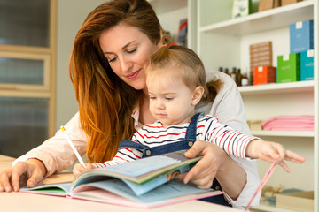 Fototapeta premium Mother mother reading book to her toddler