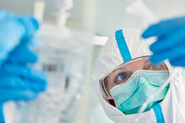 Arzt auf Intensivstation präpariert Infusion für Covid-19 Patient