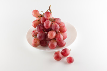 bunch of fresh grapes lies on a dinner plate
