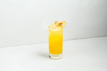 Fresh fruit yellow alcohol cocktail in a highball 