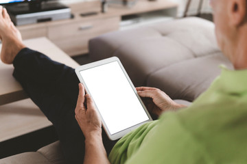 Close up of adult man hands typing on tablet - Man holding pc tablet at home with blank mock up white empty screen - mockup copyspace display for shopping online, job search, advertising