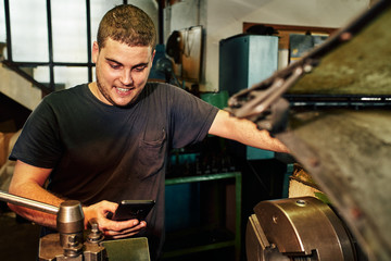 Professional machinist : man operating lathe grinding machine