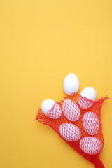Eggs,Eggs come out of the net red bag.top view yellow background easter egg