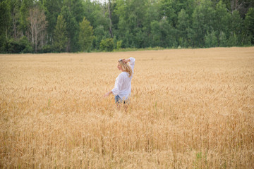 Naklejka na ściany i meble young woman in a wheat field