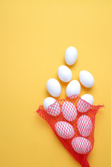 Eggs,Eggs come out of the net red bag.top view yellow background easter egg