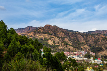 Fototapeta na wymiar high angle shot of cityscape along side mountains and trees in the foreground