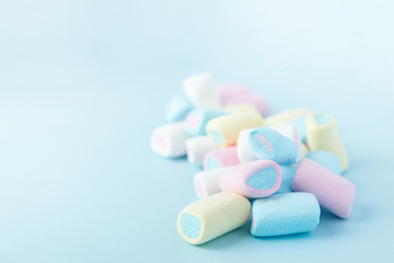 Obraz na płótnie Canvas bright multi-colored marshmallows on a blue background