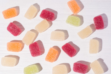 Fruit colorful marmalade sweets, jelly candies on white wooden background
