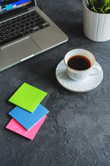 coffee mug, glasses and laptop on a black background on the table
