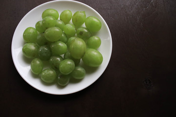 Green grapes on a white plate