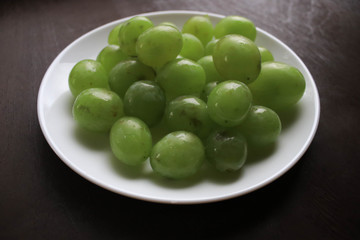 Green grapes on a white plate