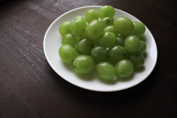 Green grapes on a white plate