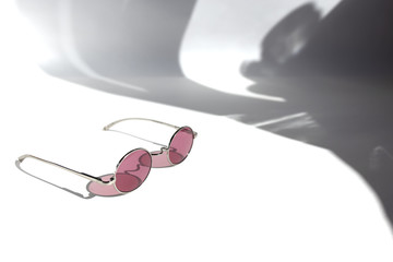 Pink sunglasses on the white background. Minimal summer concept. Copy space.Place for text and design. Isolated subject