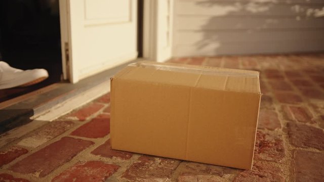 Receiver picking up package from doorstep, contactless delivery and social distancing while quarantine, getting order shipped