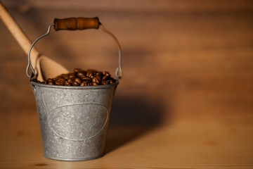 Lovely aroma coffee  grain at  iron 
pail on wooden background