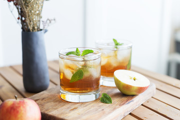 Tasty apple juice with mint and ice at wood board at the table