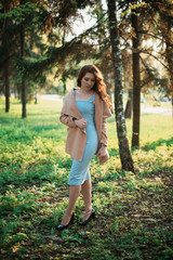 Beautiful young girl in a blue dress in a spring park