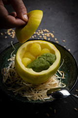 
Apple ice cream in a green apple. On a plate on a dark background