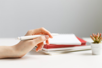 hand holds a pen on the background of notepads.