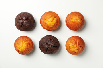 Flat lay with tasty muffins on white background, top view