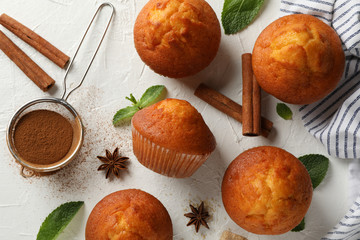 Composition with muffins and cinnamon on white background