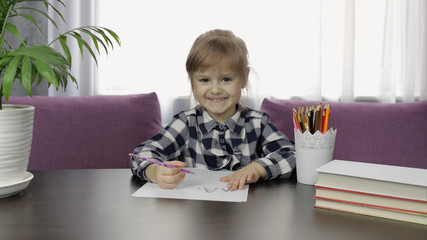 Cute child girl studying drawing picture with pencil at home. Distance education