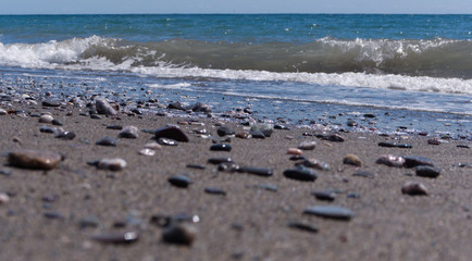 Bright sunny afternoon at the beach with shinny stones and beautiful blue ocean