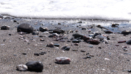 Bright sunny afternoon at the beach with shinny stones and beautiful blue ocean