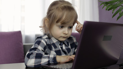 Girl doing online lessons using digital laptop computer. Distance education