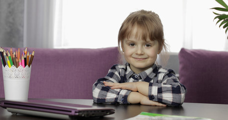 Fototapeta na wymiar Girl sitting on table at home. Studying online homework. Distance education
